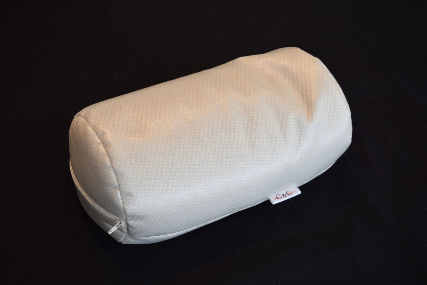 Traversin de massage Cause et Couture en tissu blanc, vue de trois quarts sur fond sombre