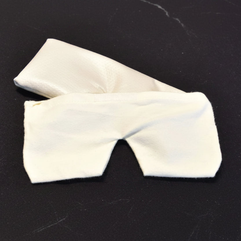 Housse en flanelle blanche par dessus un coussin repose-yeux sur fond sombre