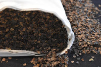 Écailles de sarrasin biologique débordant d'un sac en tissu, matière de rembourrage du traversin